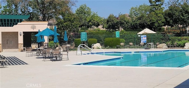 pool with a patio and fence