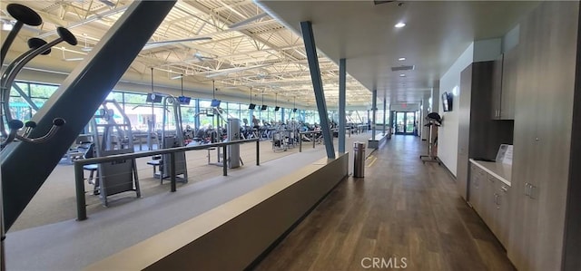 interior space with visible vents, a wall of windows, wood finished floors, and a wealth of natural light