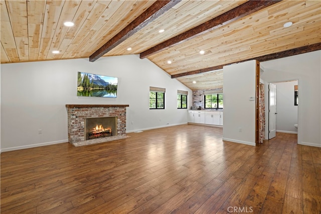 unfurnished living room with wood ceiling, lofted ceiling with beams, a brick fireplace, and hardwood / wood-style flooring