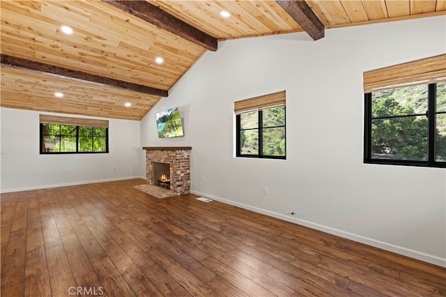 unfurnished living room with hardwood / wood-style flooring, a fireplace, lofted ceiling with beams, and wooden ceiling