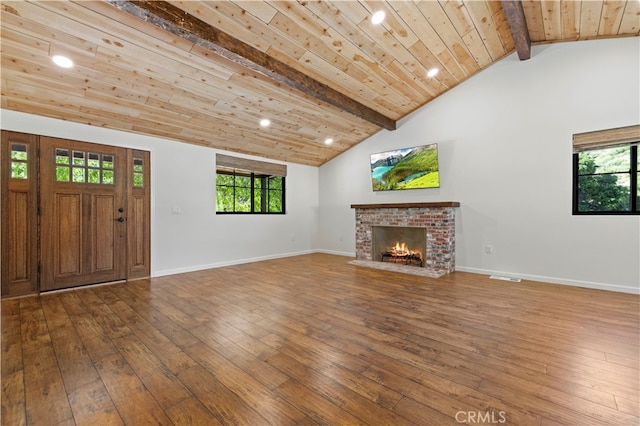 unfurnished living room featuring vaulted ceiling with beams, a fireplace, hardwood / wood-style floors, and wood ceiling