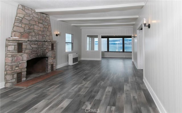 unfurnished living room with beamed ceiling, dark hardwood / wood-style floors, a fireplace, and heating unit