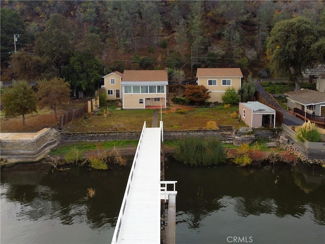 view of dock featuring a lawn and a water view