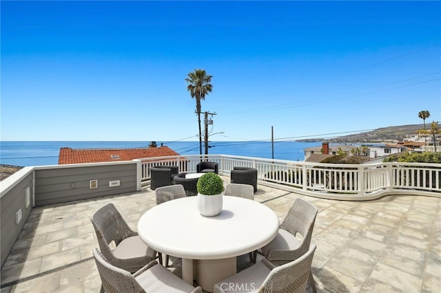 view of patio with outdoor dining area and a water view