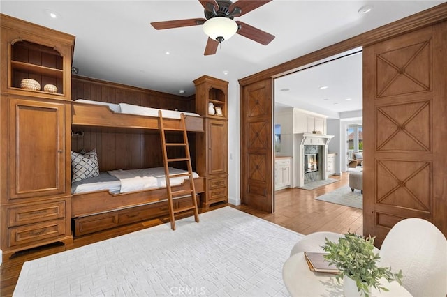 bedroom featuring recessed lighting, wood finished floors, and a high end fireplace