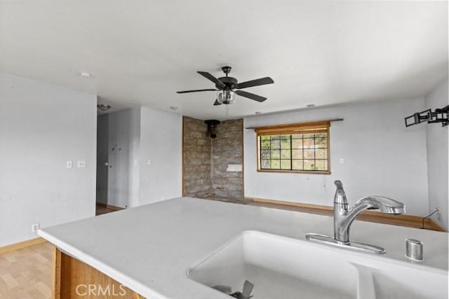 kitchen featuring light wood-type flooring, ceiling fan, and sink