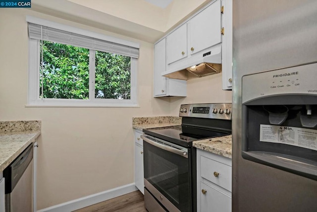 kitchen with white cabinetry, light hardwood / wood-style flooring, stainless steel appliances, and light stone counters