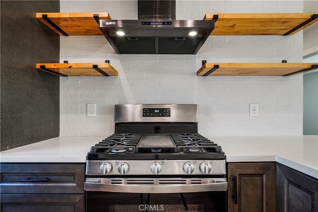 kitchen with open shelves, wall chimney exhaust hood, stainless steel range with gas cooktop, and decorative backsplash