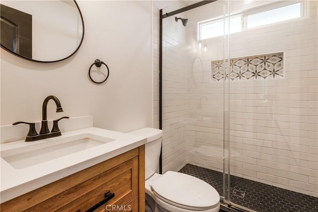 full bathroom featuring a stall shower, vanity, and toilet