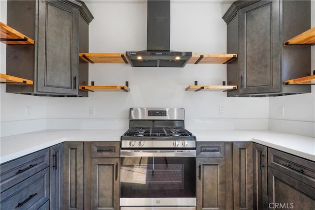 kitchen with stainless steel gas stove, open shelves, exhaust hood, and light countertops