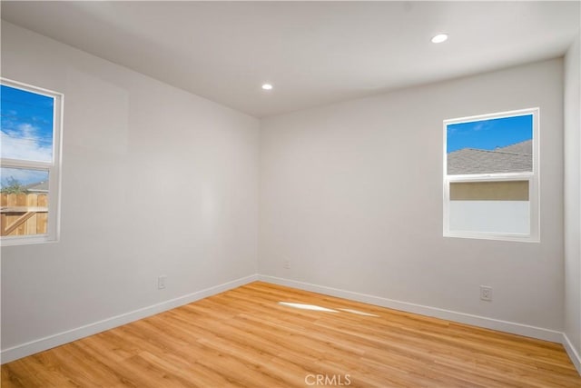 unfurnished room with recessed lighting, baseboards, and light wood finished floors