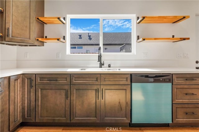 kitchen with dishwashing machine, open shelves, a sink, and light countertops