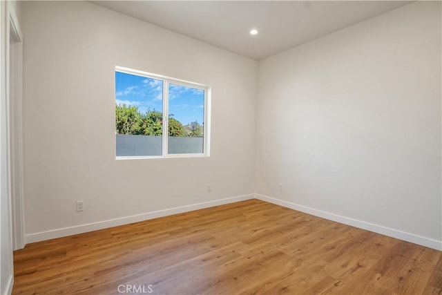 unfurnished room featuring light wood-type flooring, baseboards, and recessed lighting