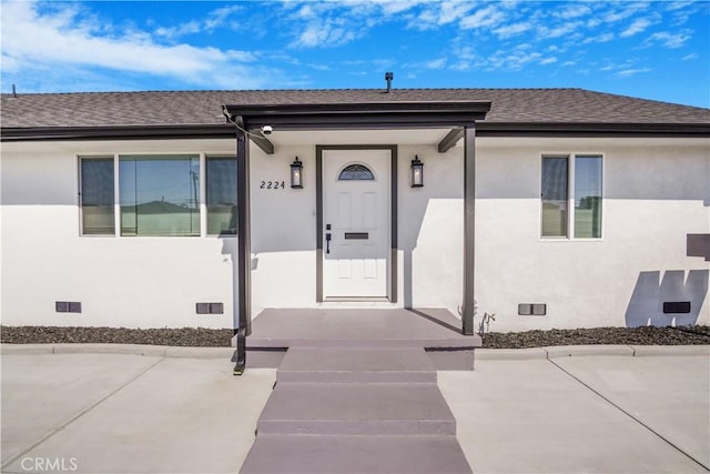 entrance to property with crawl space, roof with shingles, and stucco siding