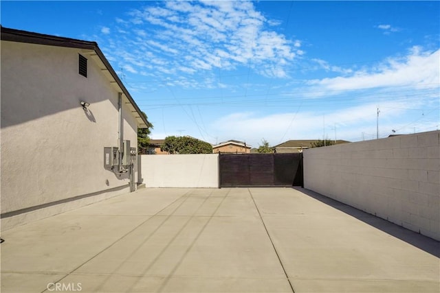 view of patio featuring fence and a gate