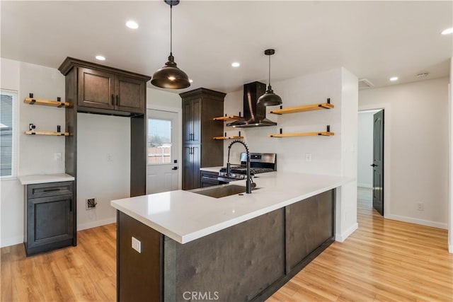 kitchen with a peninsula, island exhaust hood, light countertops, dark brown cabinets, and open shelves