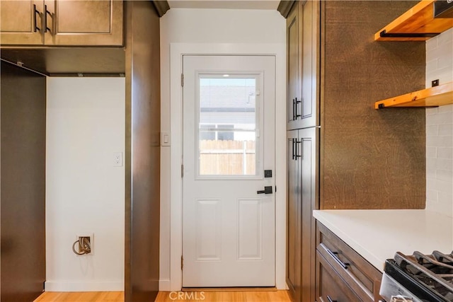 doorway to outside featuring baseboards and light wood finished floors