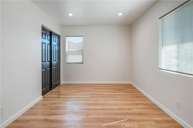 spare room featuring baseboards, light wood-style flooring, and recessed lighting