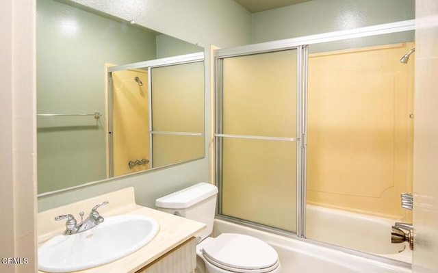 full bathroom with vanity, enclosed tub / shower combo, and toilet