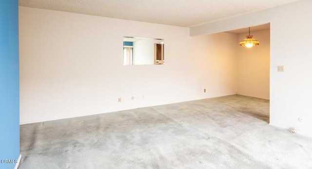 carpeted empty room featuring a textured ceiling