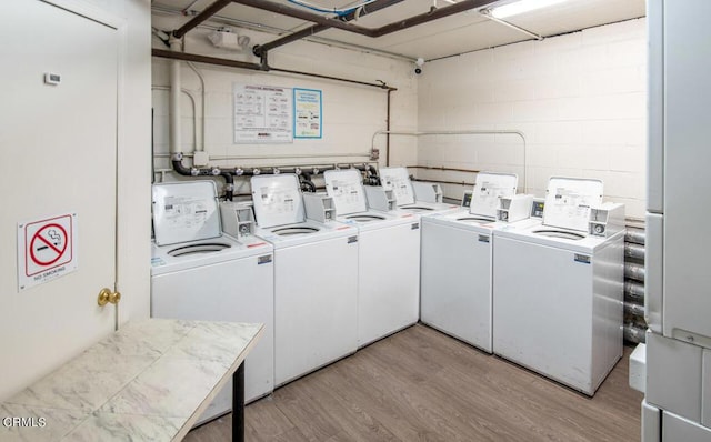 laundry room featuring light hardwood / wood-style floors and washing machine and clothes dryer