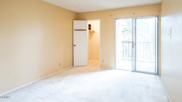 spare room featuring light carpet and a textured ceiling