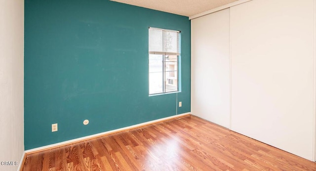 empty room with a textured ceiling and light wood-type flooring