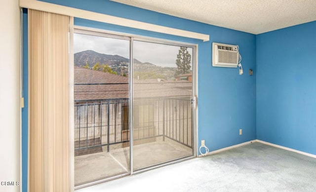 entryway with a mountain view, a textured ceiling, carpet floors, and an AC wall unit