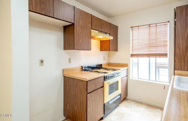 kitchen featuring plenty of natural light, range with gas cooktop, and sink