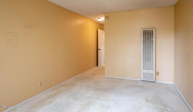 unfurnished room featuring light carpet and a textured ceiling