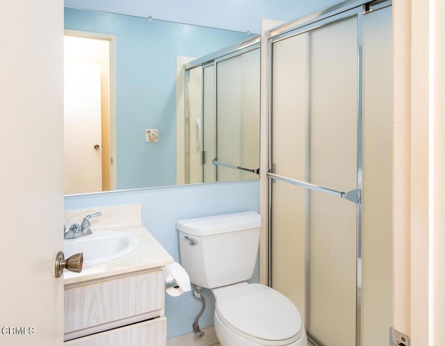 bathroom featuring an enclosed shower, vanity, and toilet