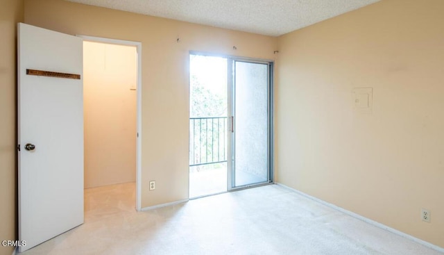 carpeted empty room featuring a textured ceiling