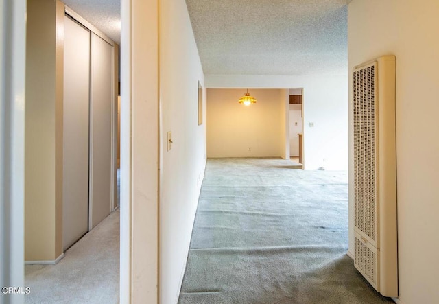 hallway featuring carpet floors and a textured ceiling