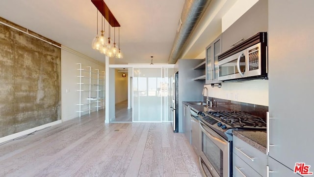 kitchen featuring sink, stainless steel appliances, light hardwood / wood-style flooring, crown molding, and pendant lighting