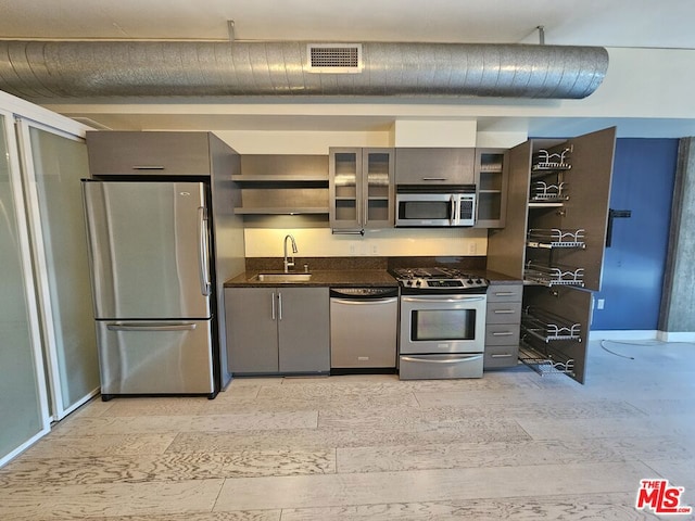 kitchen featuring dark stone counters, sink, and stainless steel appliances