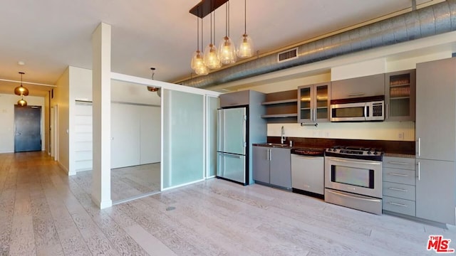 kitchen featuring sink, light hardwood / wood-style flooring, pendant lighting, and appliances with stainless steel finishes