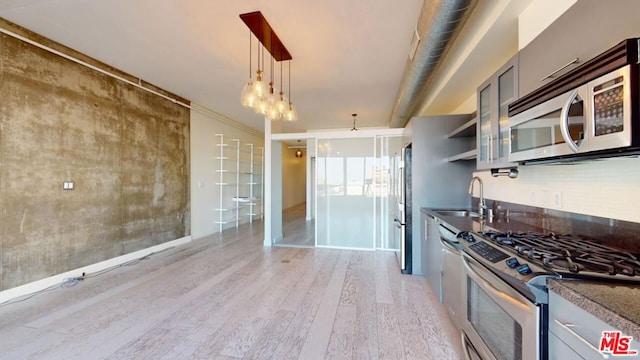 kitchen featuring appliances with stainless steel finishes, light wood-type flooring, crown molding, sink, and pendant lighting