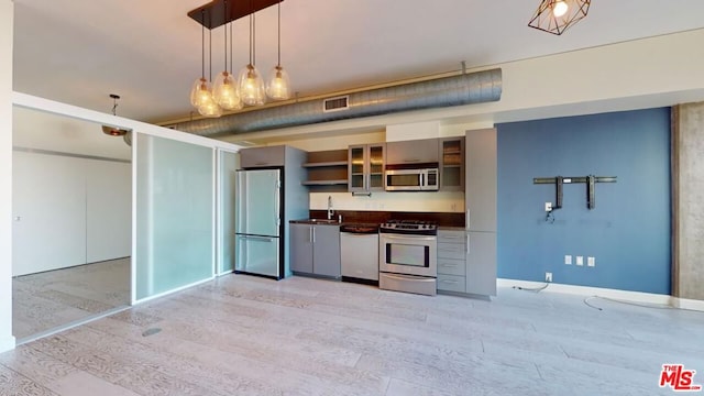 kitchen featuring pendant lighting, light hardwood / wood-style flooring, stainless steel appliances, and sink