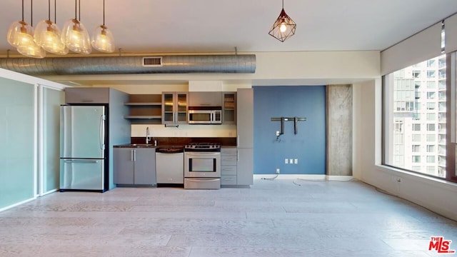 kitchen with sink, light hardwood / wood-style flooring, pendant lighting, and appliances with stainless steel finishes