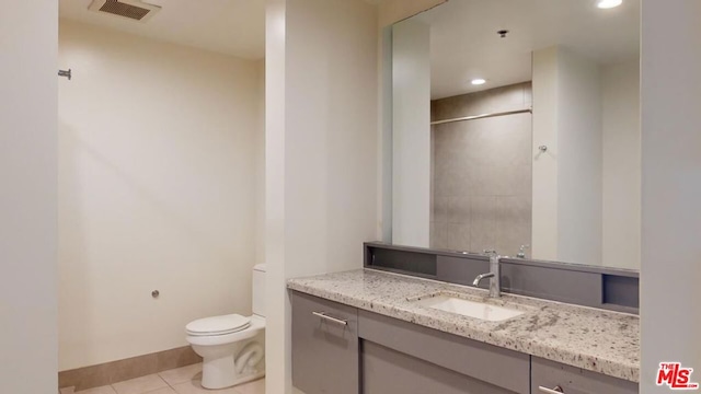 bathroom featuring tile patterned flooring, vanity, and toilet