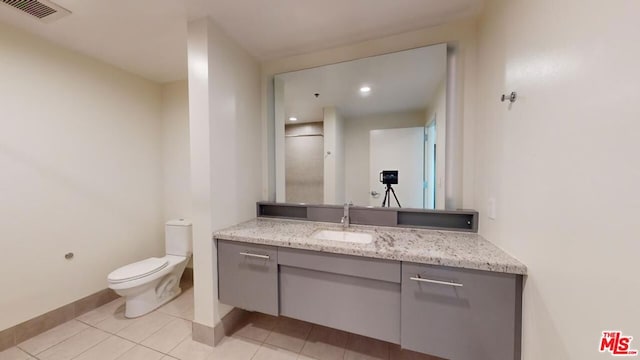 bathroom with tile patterned flooring, vanity, and toilet