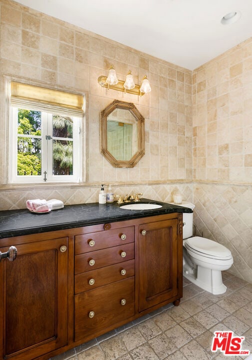 bathroom featuring vanity, tile floors, and tile walls