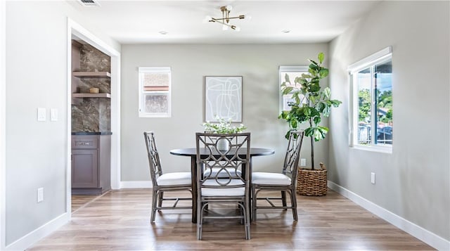 dining area featuring light wood-type flooring and a chandelier