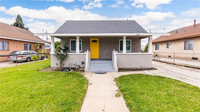 bungalow featuring a porch and a front lawn