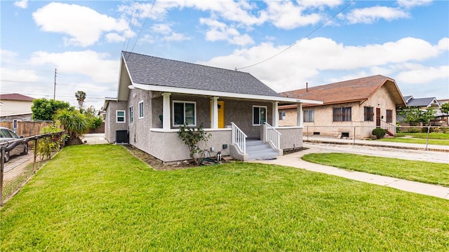 bungalow featuring a front lawn and central air condition unit