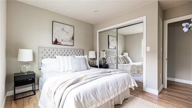 bedroom with light wood-type flooring and a closet