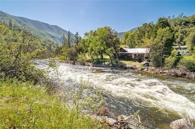 property view of water featuring a wooded view and a mountain view