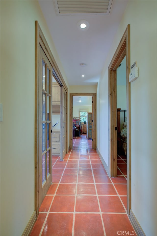 hall with tile patterned floors