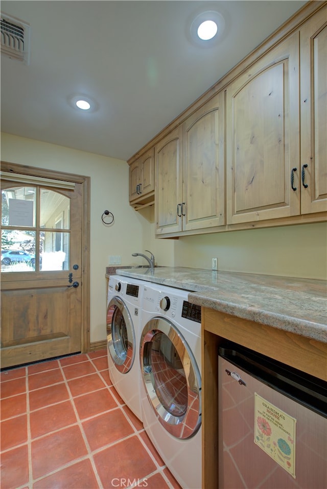 laundry room with tile patterned floors, cabinets, and separate washer and dryer