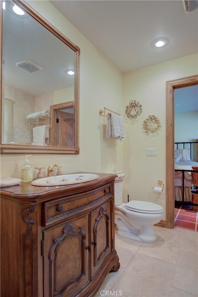 bathroom with vanity, a shower, toilet, and tile patterned floors